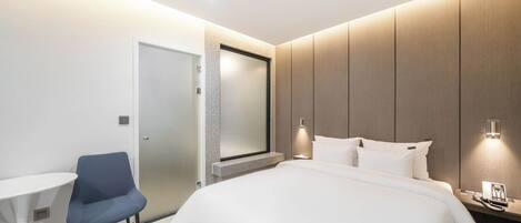 Una habitación de hotel moderna con cama, escritorio y silla.