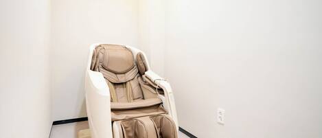 A massage chair in a room with white walls and a light-colored floor.