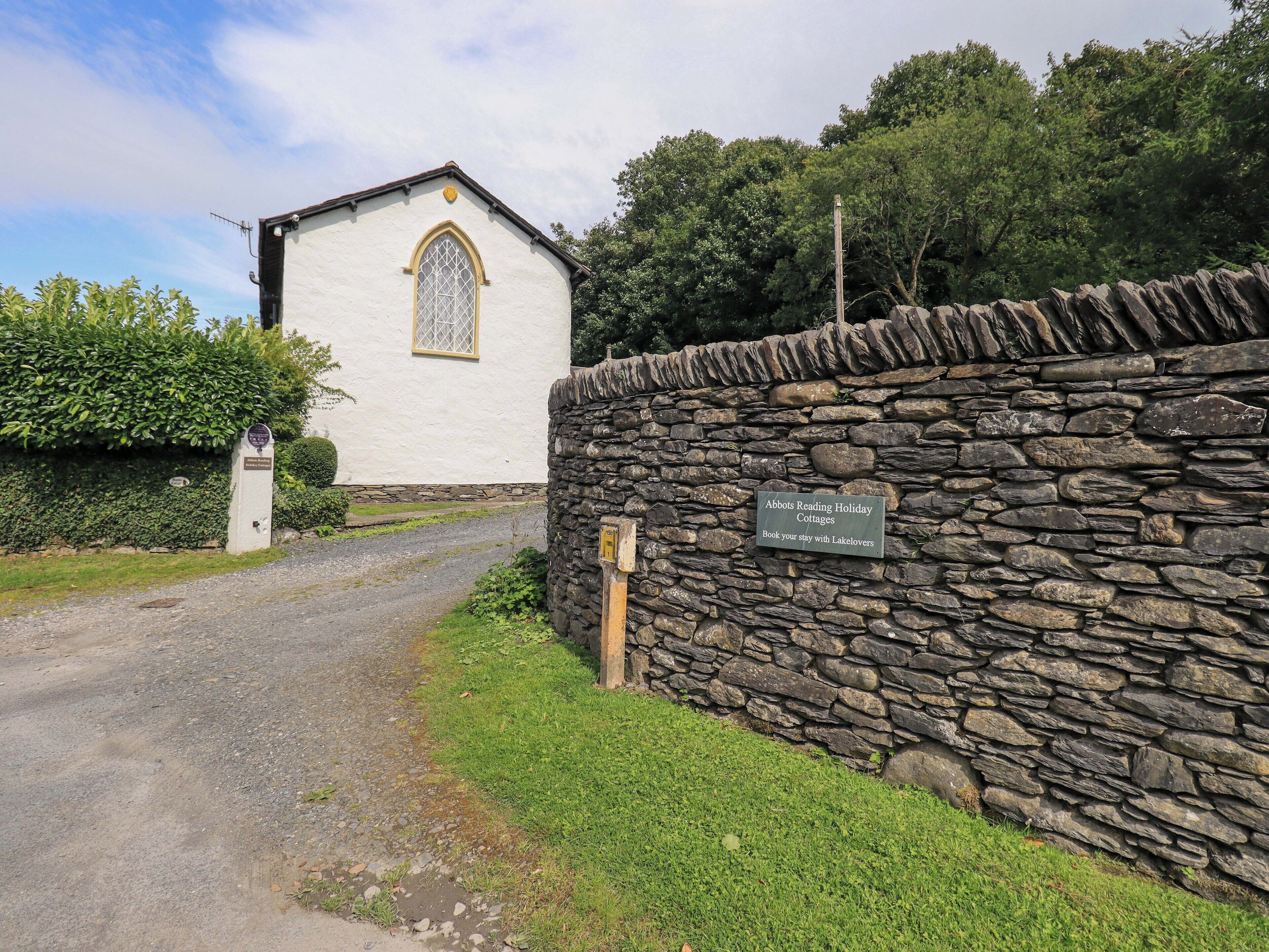 A stone wall with a sign for Abbotts Reading Holiday Cottages.