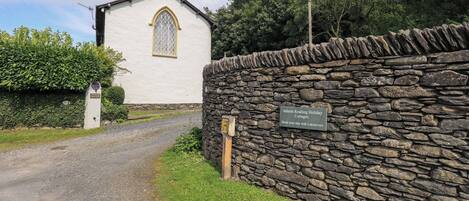 A stone wall with a sign for Abbotts Reading Holiday Cottages.