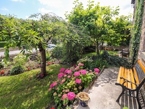 A garden with a bench, a stone wall, and various plants. - Cherry Tree Cottage (Bakewell)
