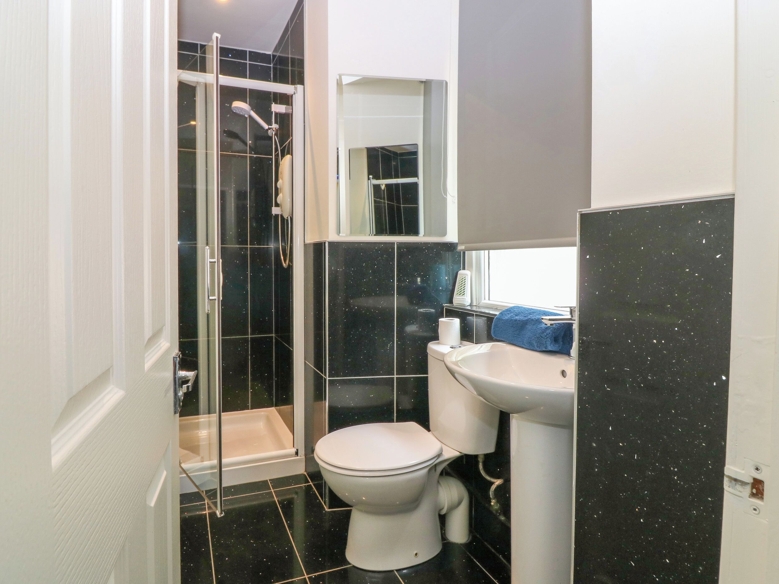 A bathroom with a shower, toilet, and sink.