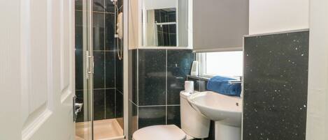 A bathroom with a shower, toilet, and sink.