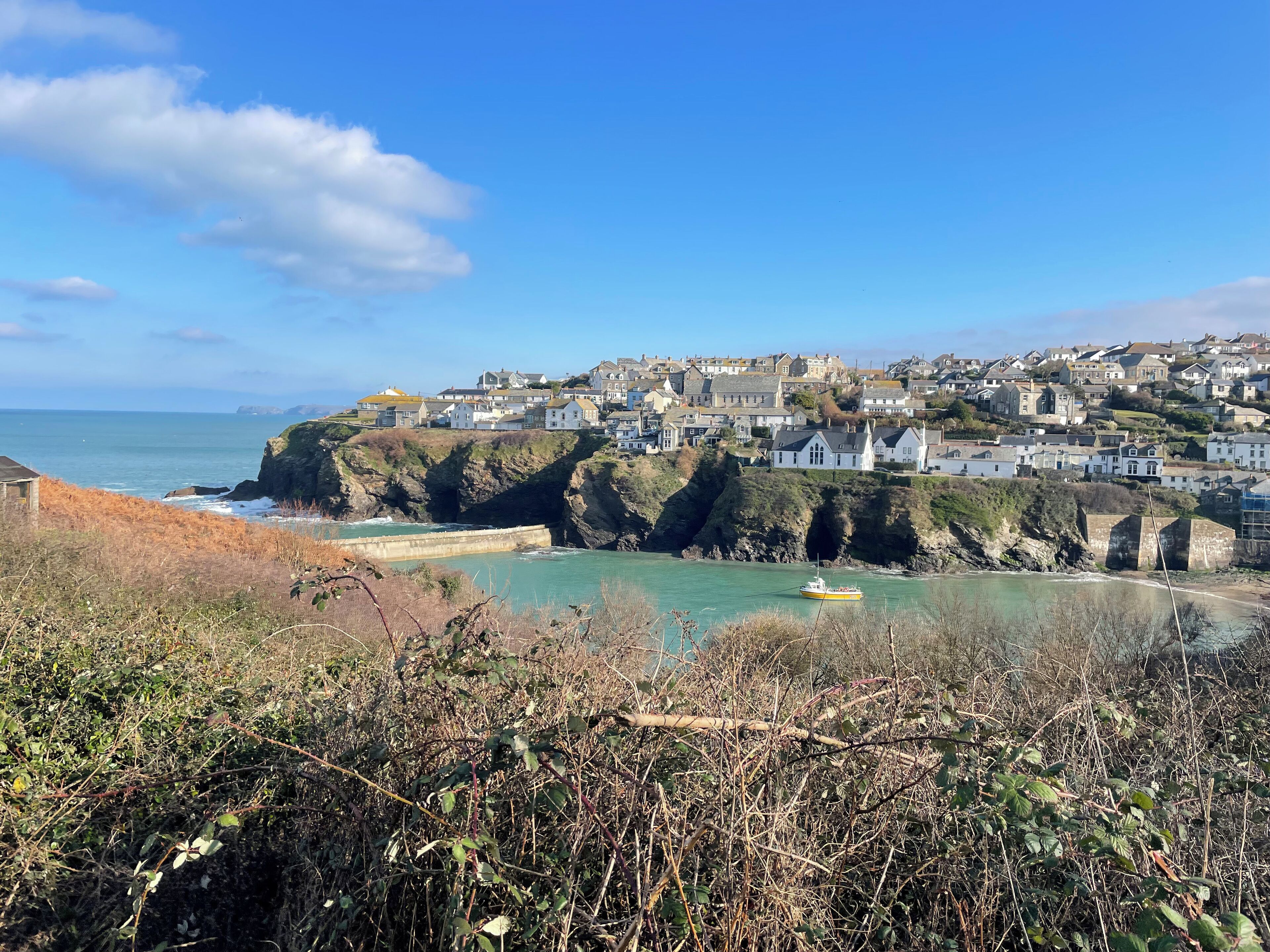 A coastal town with houses on a cliff overlooking the sea.