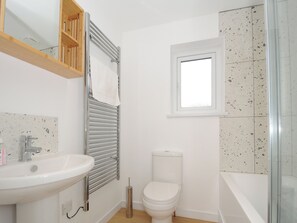 A bathroom with a white sink, toilet, and a glass shower enclosure. - Sea Spray (Port Isaac)