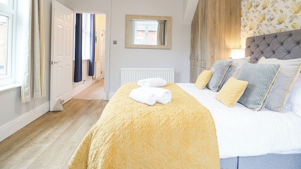 Une chambre à coucher avec un grand lit, une fenêtre avec des rideaux, un radiateur et une armoire.