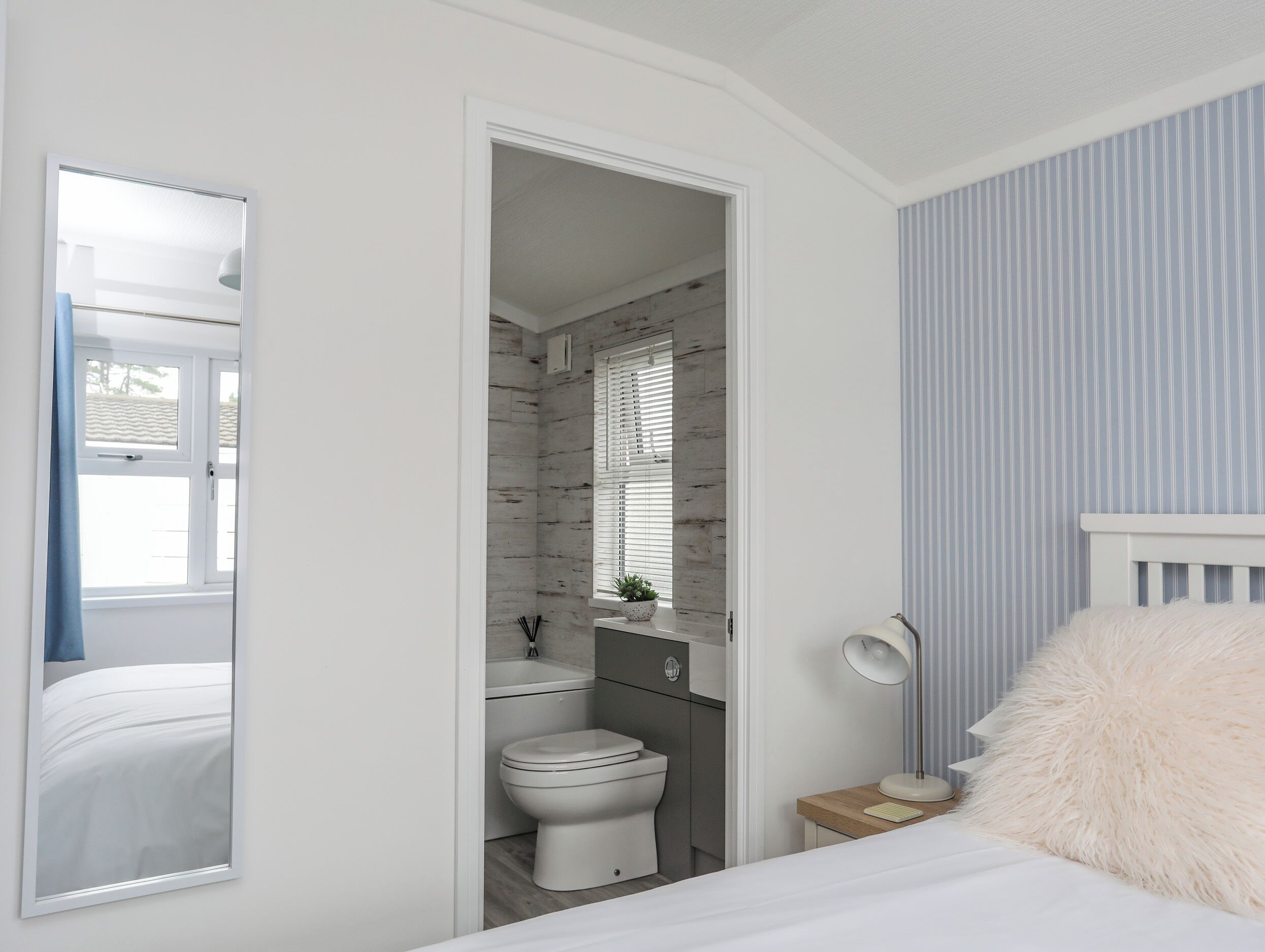 Una camera da letto con un letto, una lampada da comodino e un cuscino soffice.