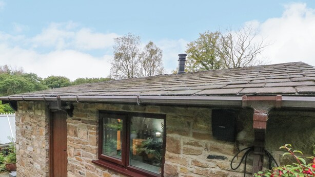 A stone cottage with a small window and a chimney. - The Bothy (Bolton)