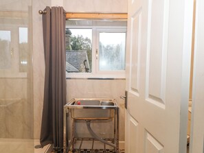 A bathroom with a window, a shower, and a sink. - The Bothy (Bolton)