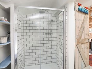 A shower with white tiled walls and a glass door. - Lle Te (Pwllheli)