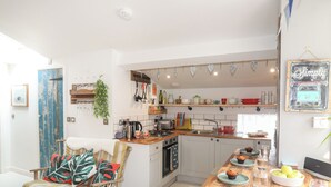 A kitchen with a wooden table, a chair, and a dining area.