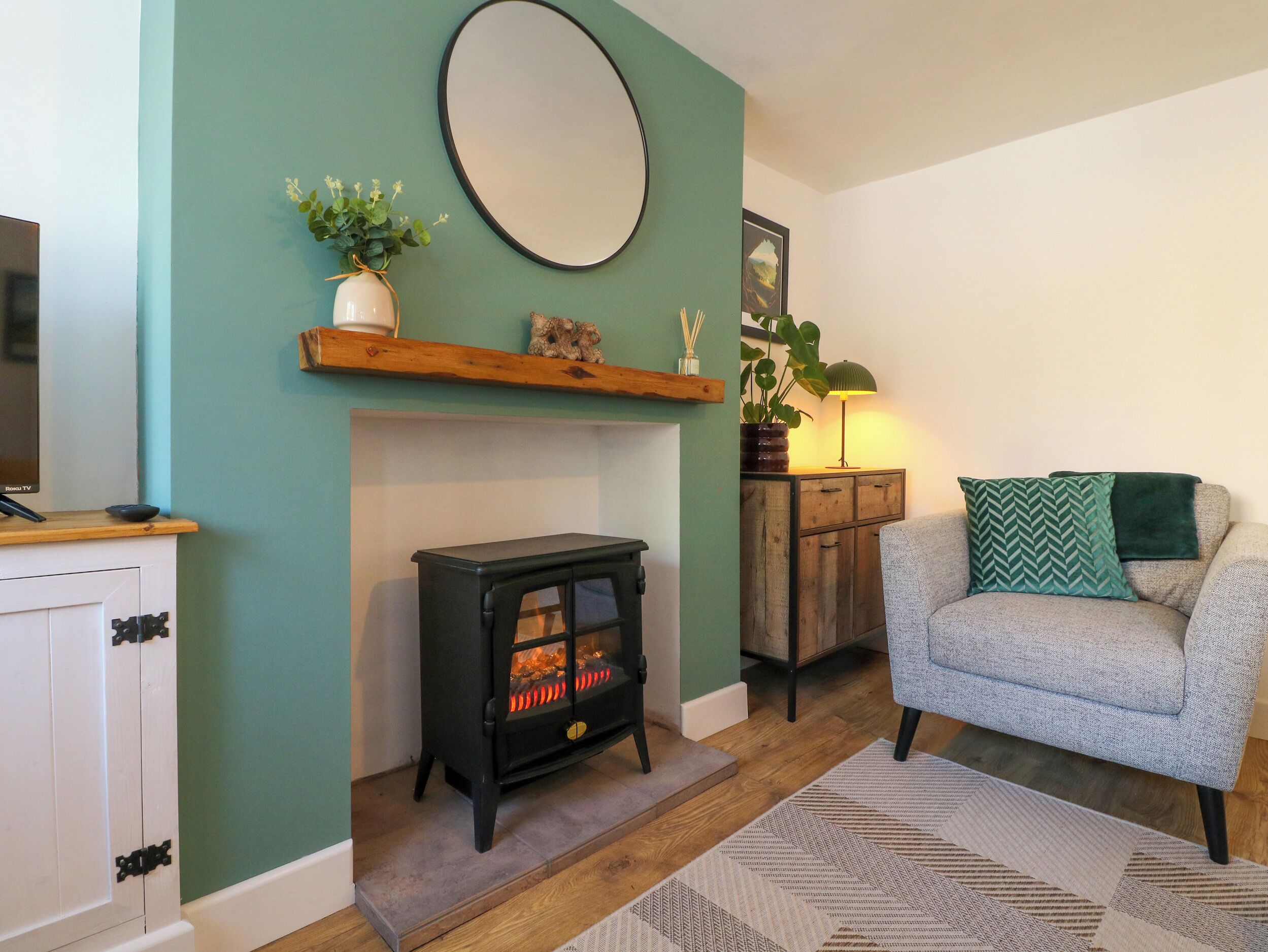 A cozy living room with a fireplace, a sofa, and a TV.