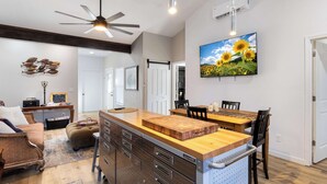 Une cuisine moderne dotée d’un îlot central, de meubles en bois et d’un ventilateur de plafond.