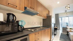 Een moderne keuken met houten kastjes, een inbouwfornuis en een koffiezetapparaat.