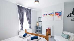 Een moderne slaapkamer met een houten bed, een witte bank en een open haard.