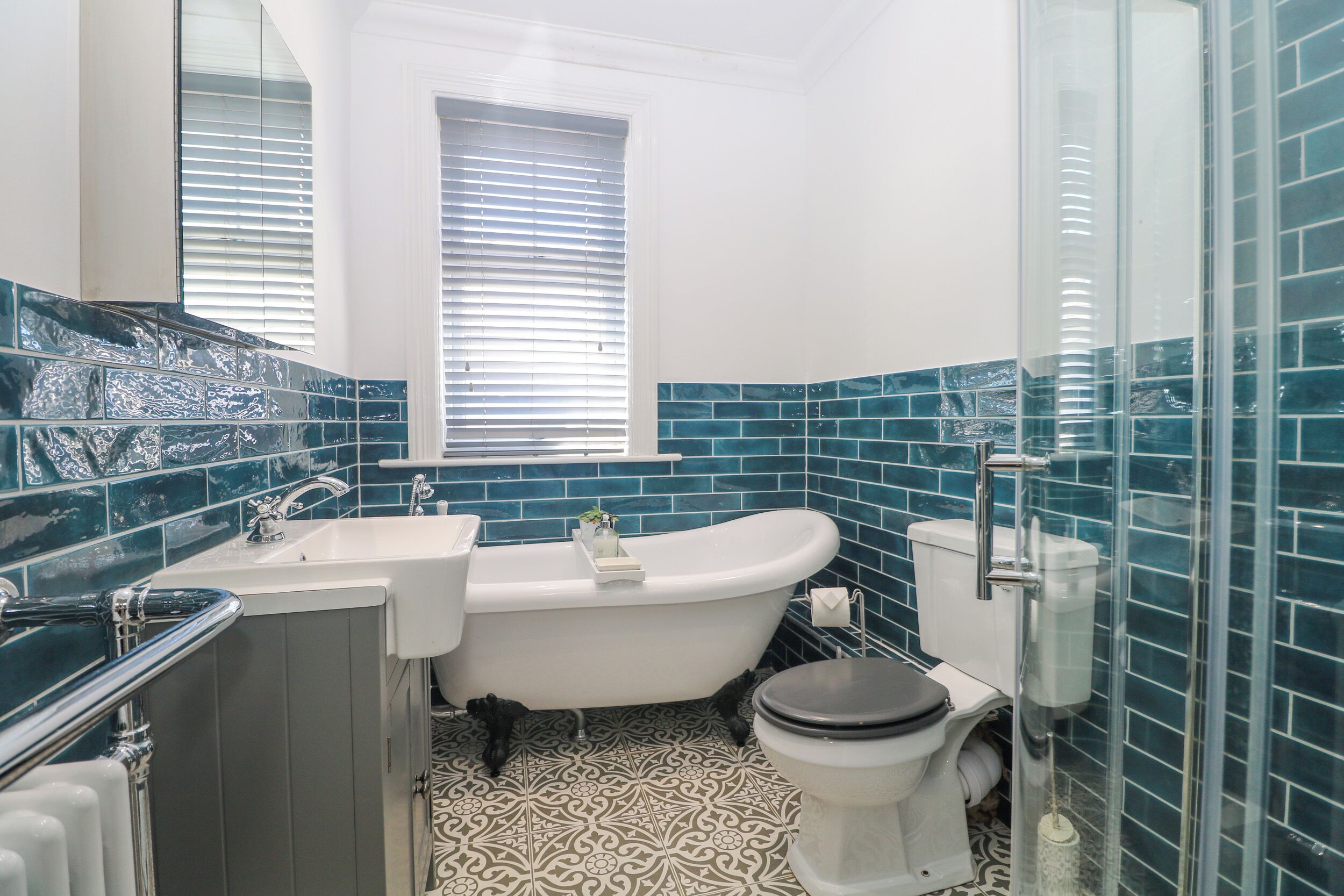 A bathroom with a freestanding bathtub, a toilet, and a glass shower enclosure.