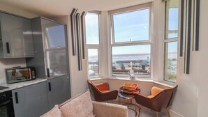 A modern kitchen with a microwave, cabinets, and a view through large windows. - Apt 4 @ Hunter's Quay (Bridlington)