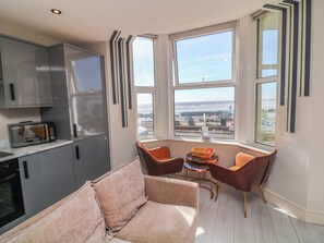 Una cocina moderna con microondas, armarios y vistas amplias a través de grandes ventanas.