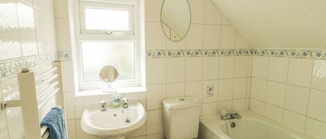 A bathroom with a toilet, sink, and bathtub.