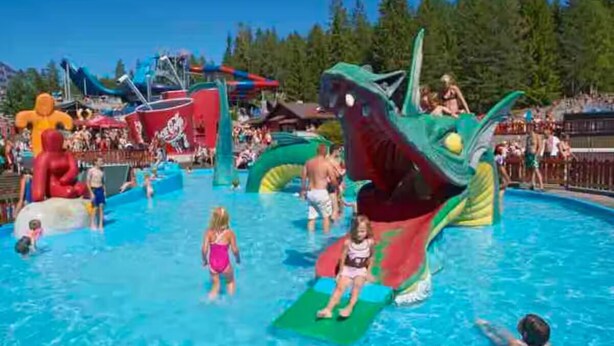 Une piscine dotée de plusieurs toboggans et de structures gonflables.