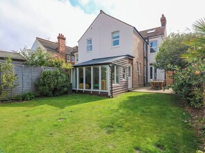 A two-story house with a conservatory, a fenced backyard, and a garden. - Greylag (Hunstanton)