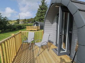 A deck with two chairs and a door to a covered area. - Dysynni Pod (Tywyn)