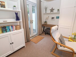 A cozy reading nook with a bookshelf, a desk, and a comfortable chair.