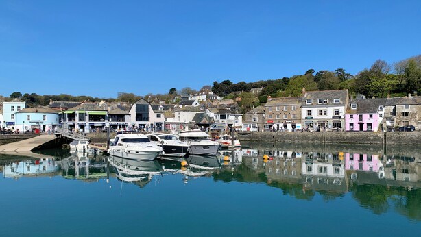 A harbor with boats docked, buildings along the waterfront, and a clear blue sky. - 2 Boathouse Terrace (Wadebridge)