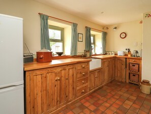 Une cuisine avec des meubles de rangement en bois, un évier et une cuisinière.