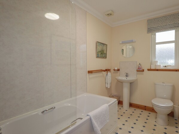 A modern bathroom with a bathtub, a sink, and a toilet.