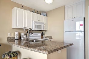 Your fully equipped kitchen awaits with crisp white cabinetry, gleaming granite countertops, and modern appliances ready for your morning coffee or a home-cooked meal. - Waterfront on the Balcony! Heated Pool & Hot Tub (St. Petersburg)
