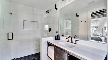 Refresh in your sleek, modern bathroom with a spacious walk-in shower, gleaming fixtures, and crisp white finishes that invite total relaxation.