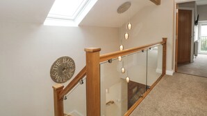 A modern staircase with glass railings, a skylight, and a decorative sign on the wall. - Small Lane Barn (Stoke-on-Trent)