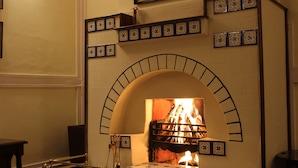 A fireplace with a brick arch and decorative tiles above it.