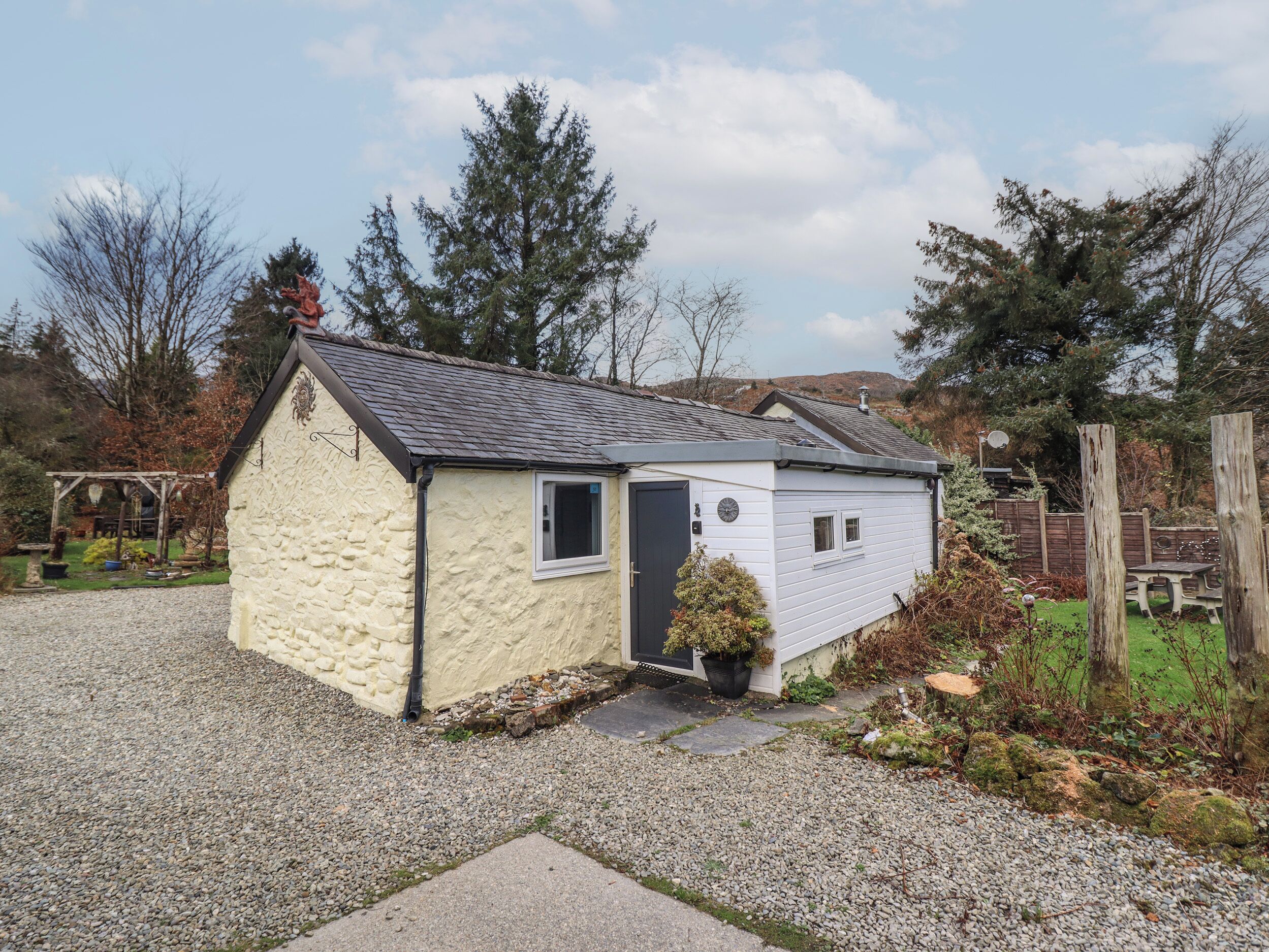 A small, single-story house with a stone exterior and a grey roof.