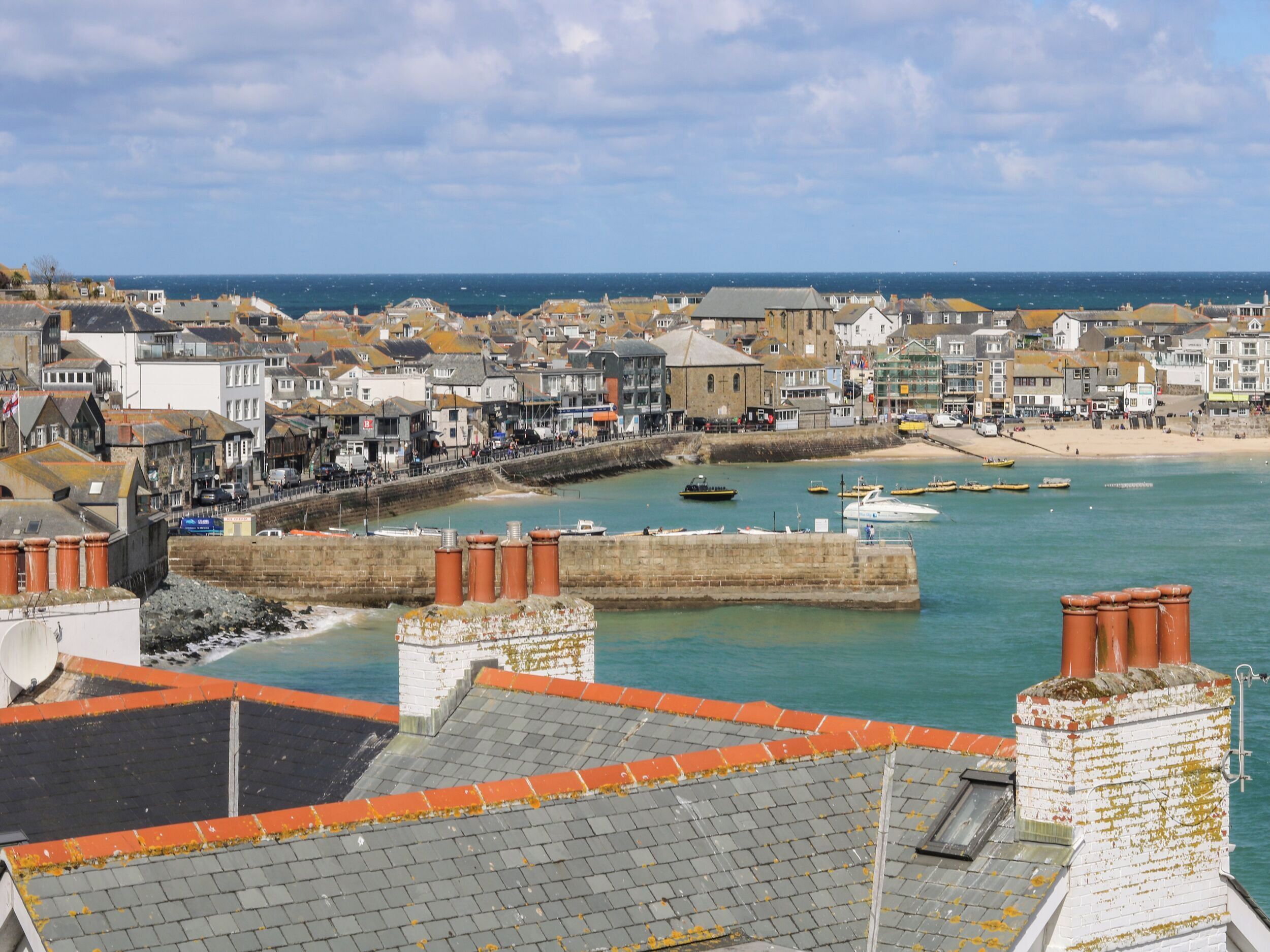 A coastal town with a harbor, buildings, and a beach.