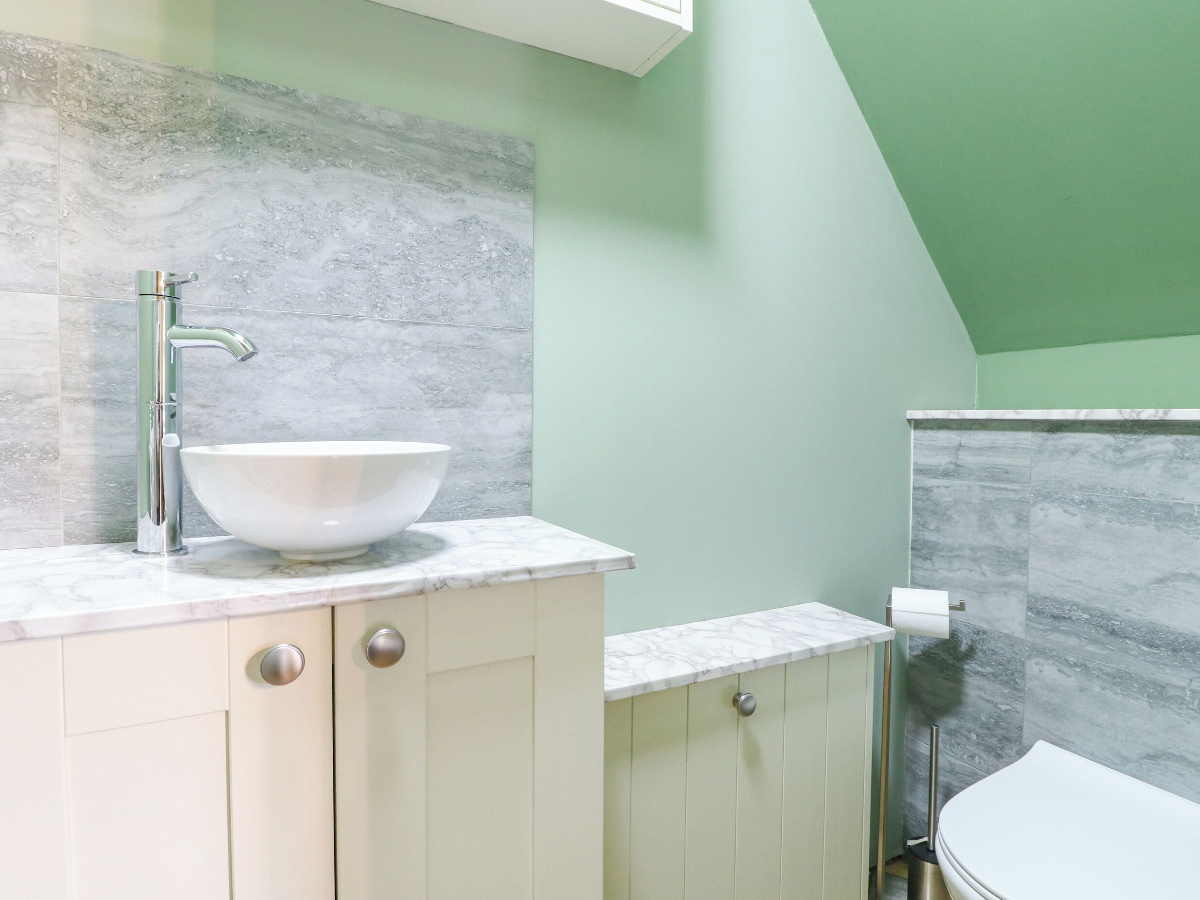 A bathroom with a white sink, a mirror, and a toilet.