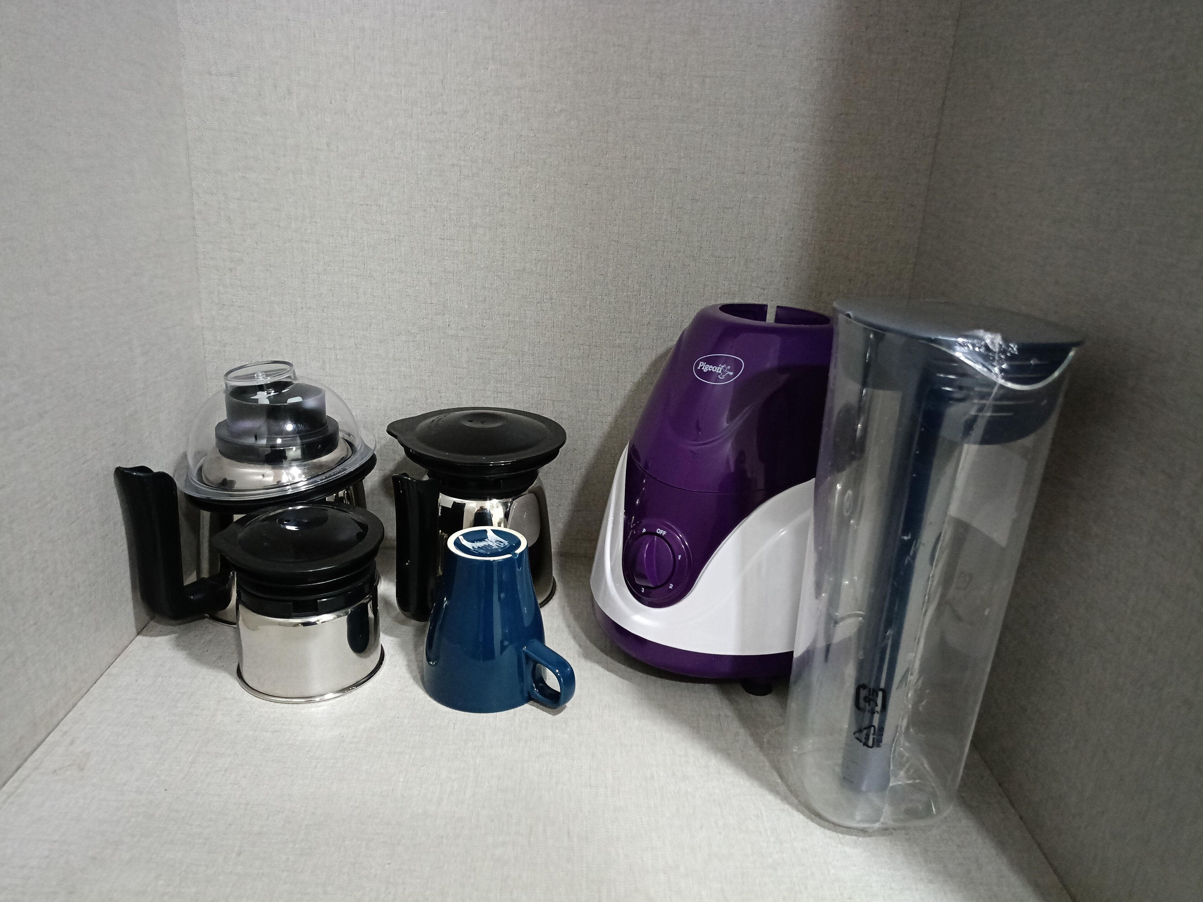 Una cocina con cafetera, hervidor, jarra de café y licuadora, todos en sus embalajes.