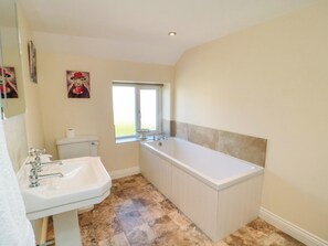 A bathroom with a sink, toilet, and bathtub. - Lilac Cottage (York)