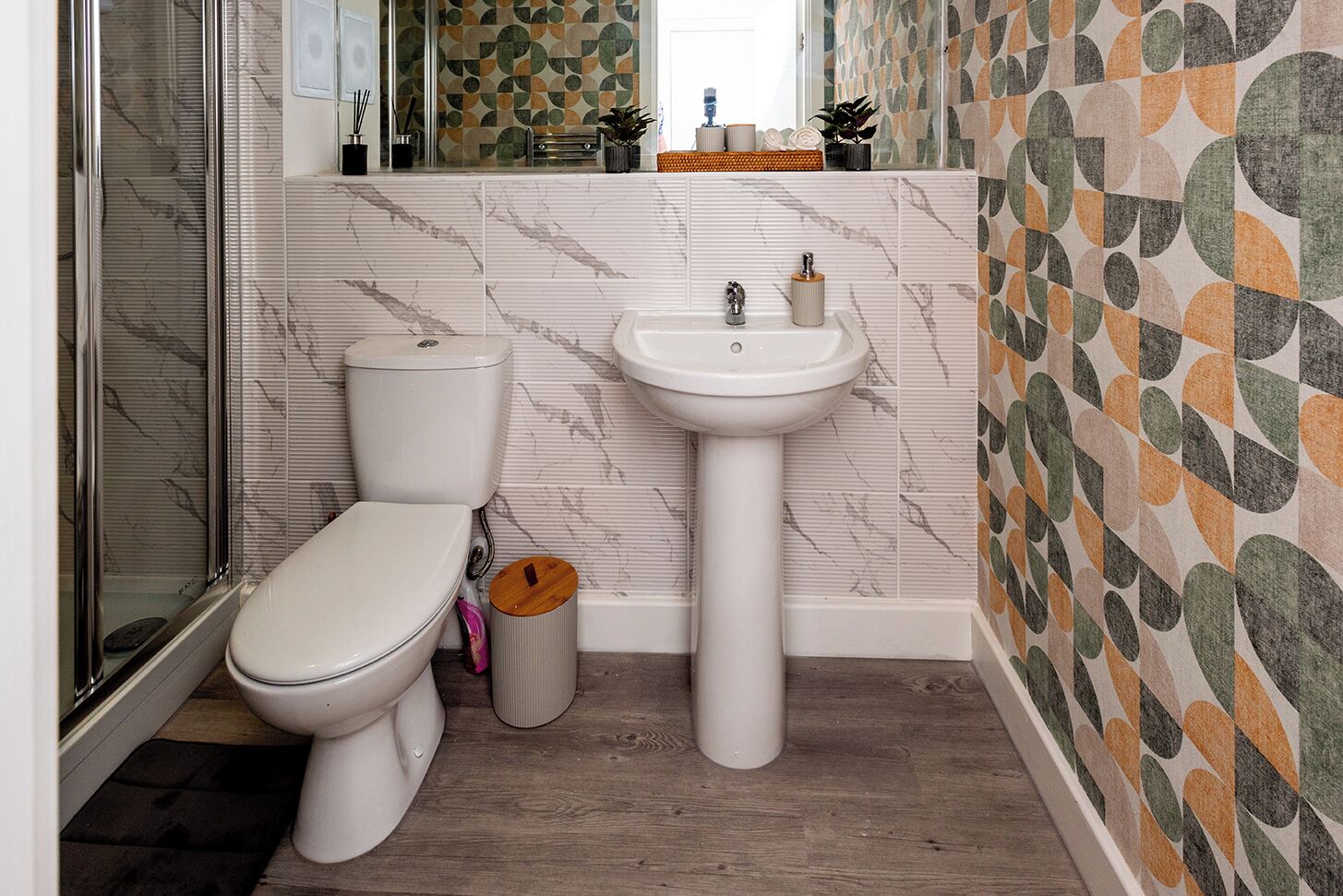 Une salle de bain avec des toilettes, un lavabo et une douche.