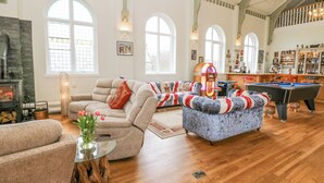 A spacious living room with a fireplace, a pool table, and a cozy seating area. - The Miners Hall Retreat (Stanley)