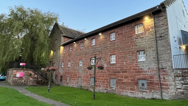 A stone building with the name "Robert Burns Centre" on its facade, featuring multiple windows and a small staircase leading to an upper level. - Ryehill With Fishing (Sanquhar)