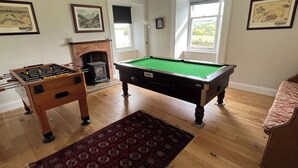 A room with a pool table, a foosball table, a fireplace, and a large window. - Ryehill With Fishing (Sanquhar)
