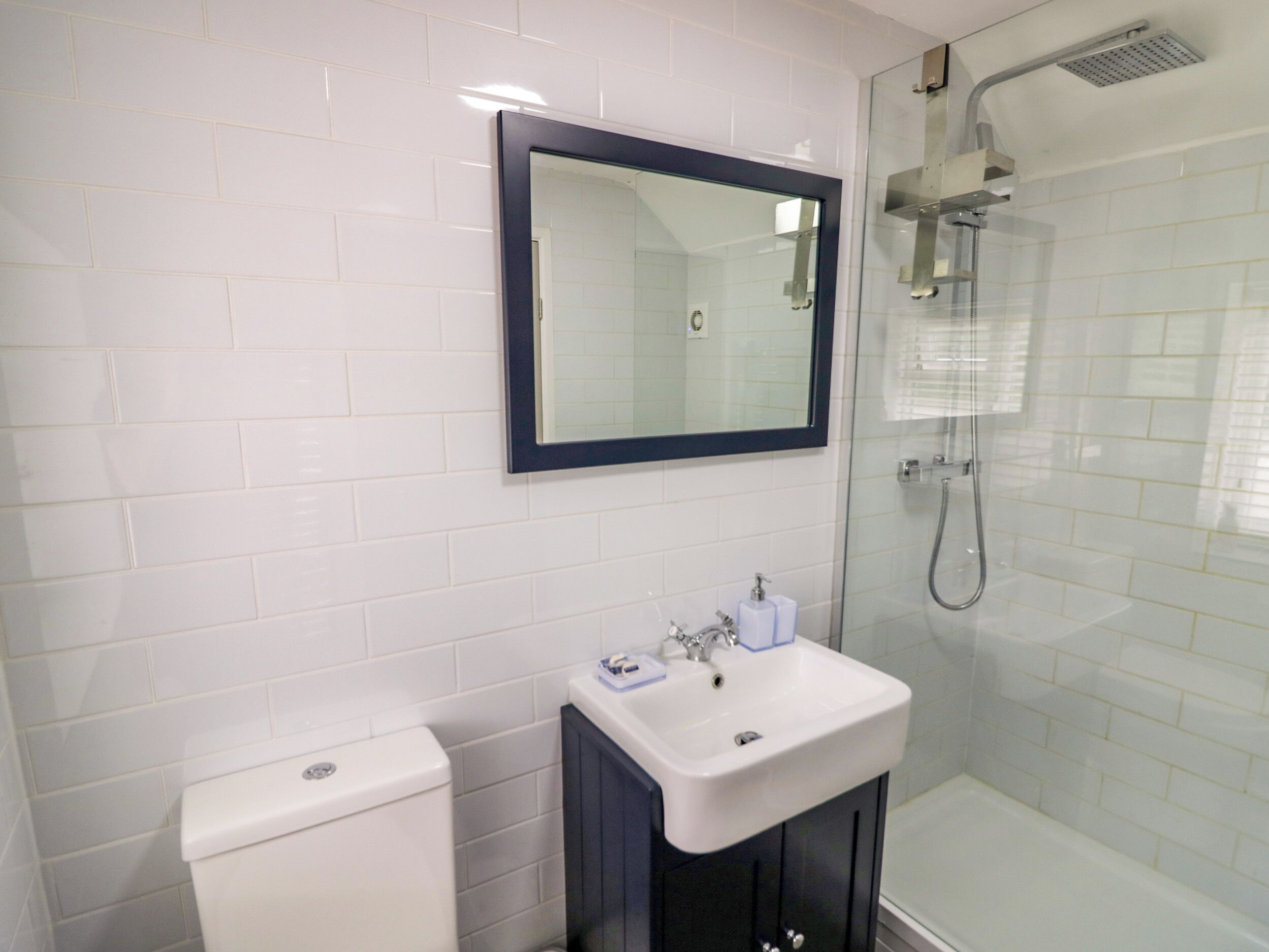 A bathroom with a toilet, sink, and shower.