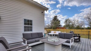 A deck with outdoor furniture including a sofa, chairs, and a coffee table. - Burrell and Flynn's Farm (Aiken)