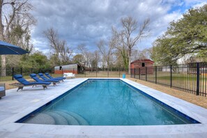 Una piscina al aire libre, sombrillas, tumbonas