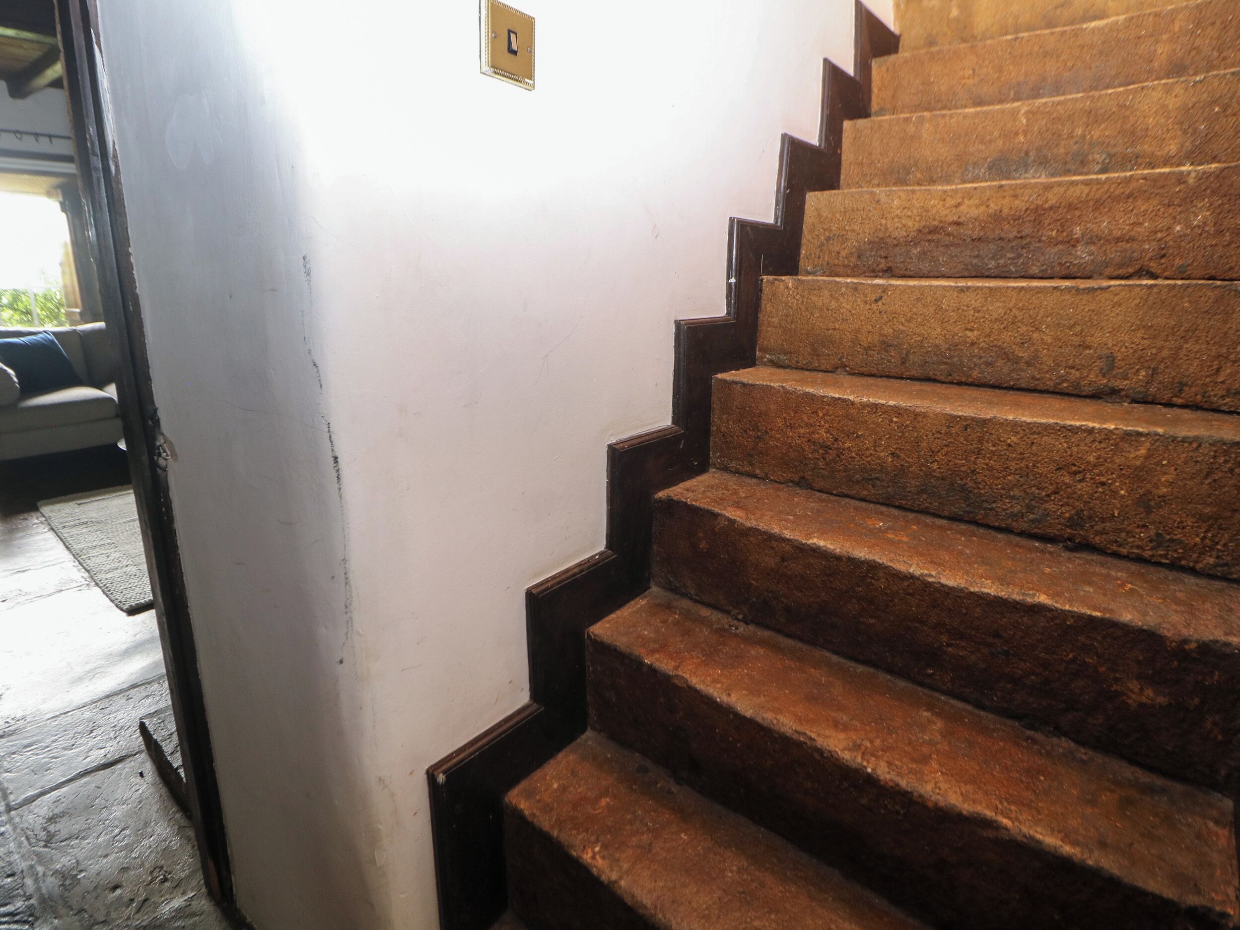 Una escalera con escalones de madera y una pared blanca.