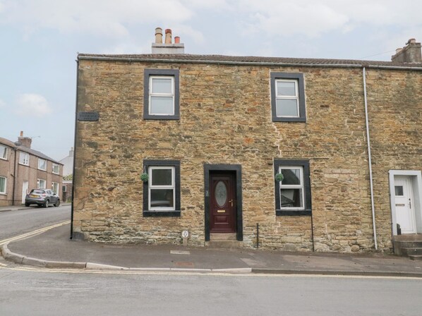 A stone building with a central door, two windows on the upper floor, and a small window on the ground floor. - 3 Nixon Terrace (Maryport)