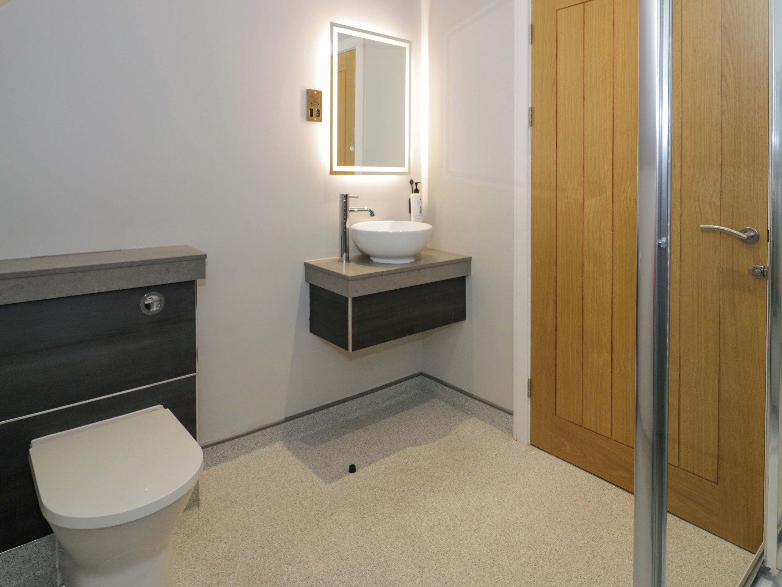 Un bagno moderno con il water, un lavandino e uno specchio.