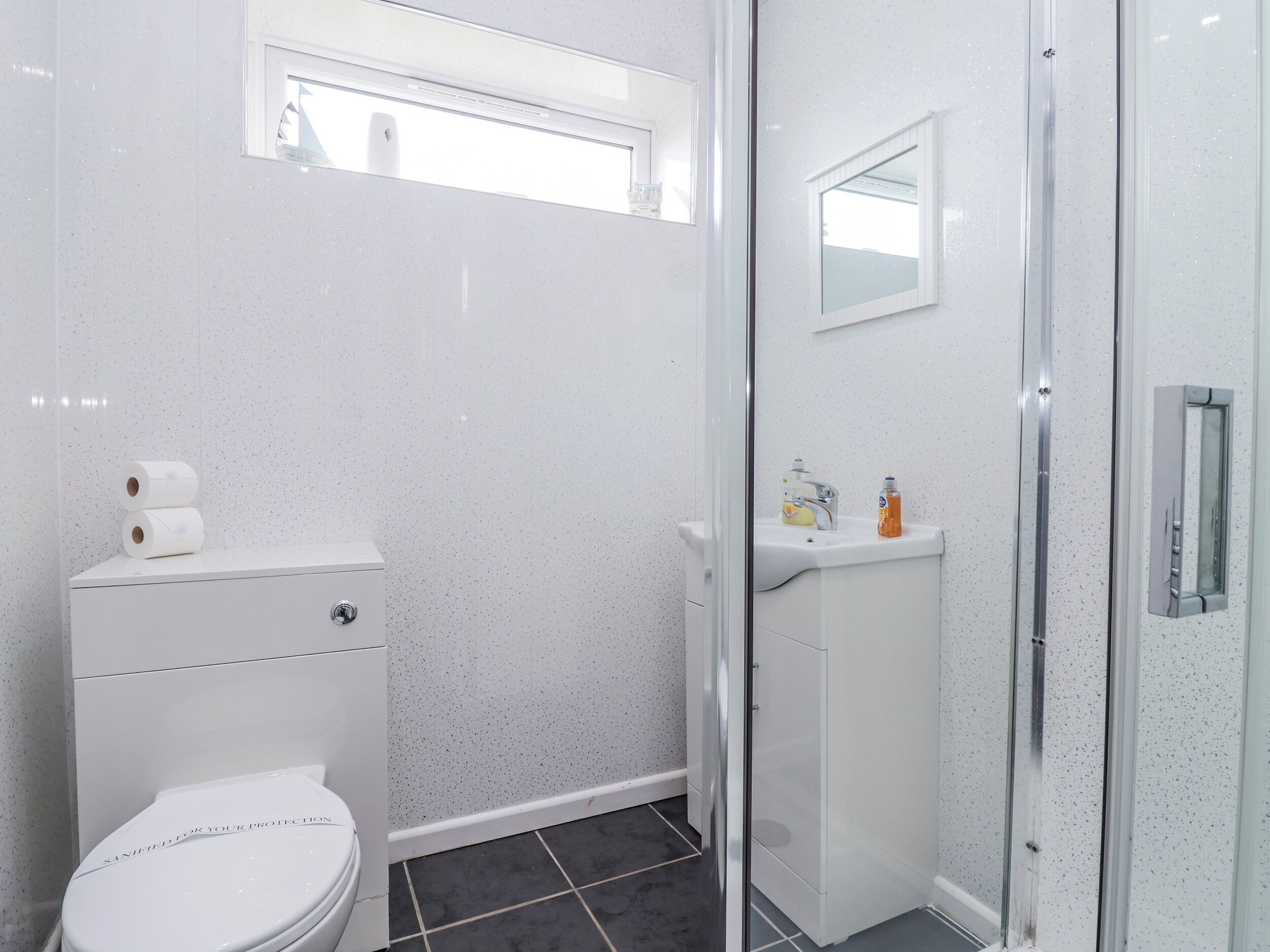 A bathroom with a toilet, a sink, and a shower.